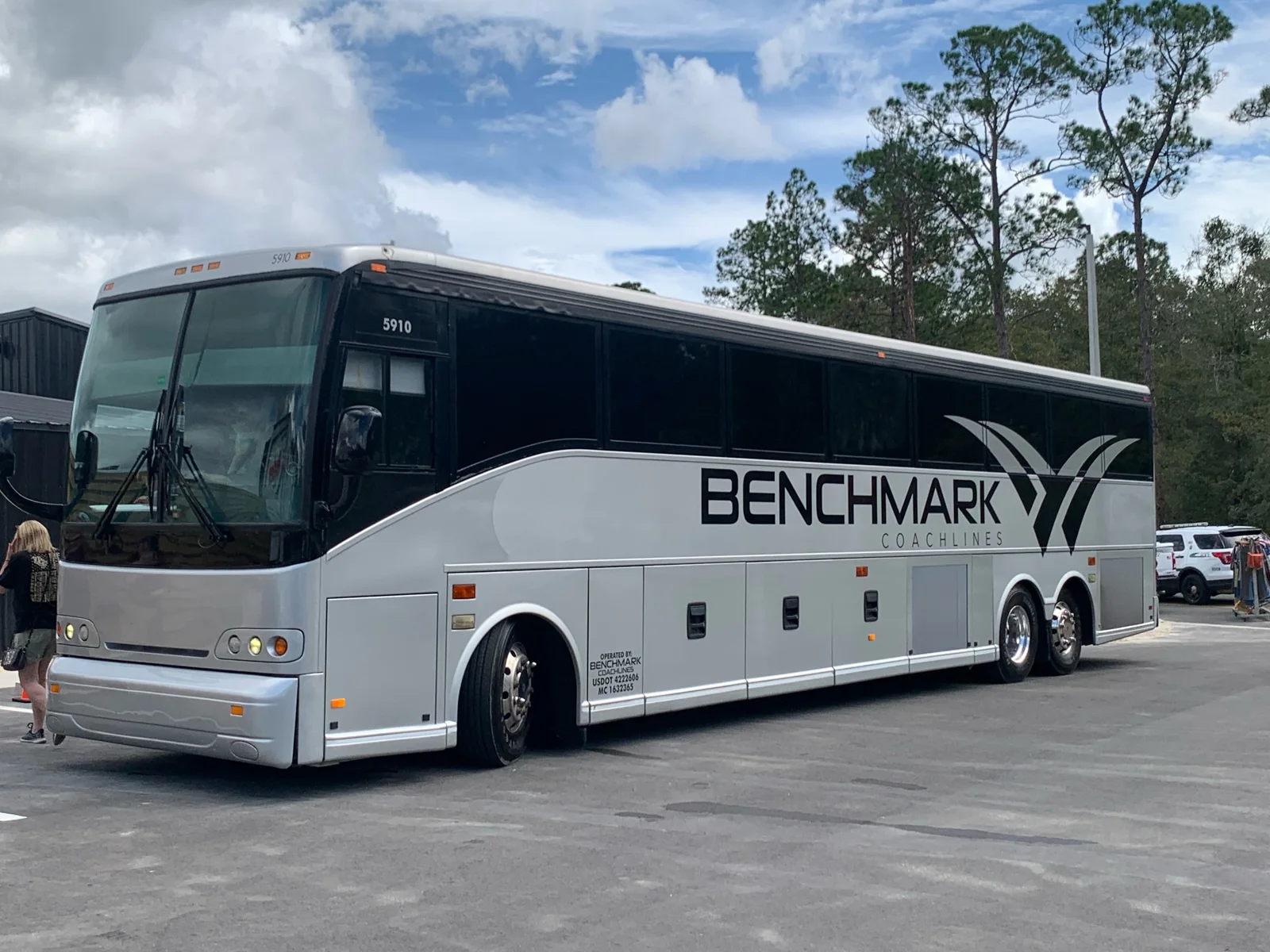 Luxury charter bus loading a large group with luggage for an airport transfer - Benchmark Coachlines