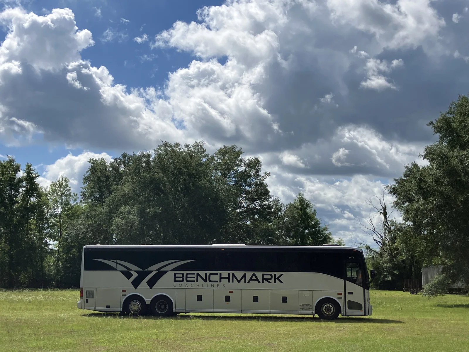 Group boarding a luxury charter bus instead of splitting into separate cars for a trip - Benchmark Coachlines