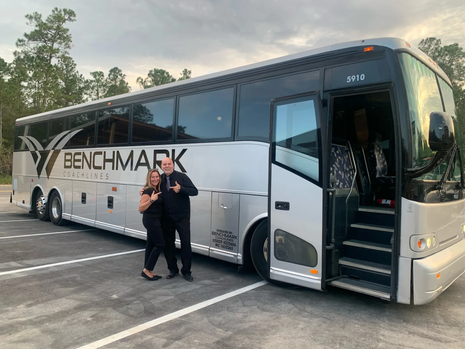 Luxury motorcoach parked outside a Gainesville convention hotel for corporate group transportation - Benchmark Coachlines