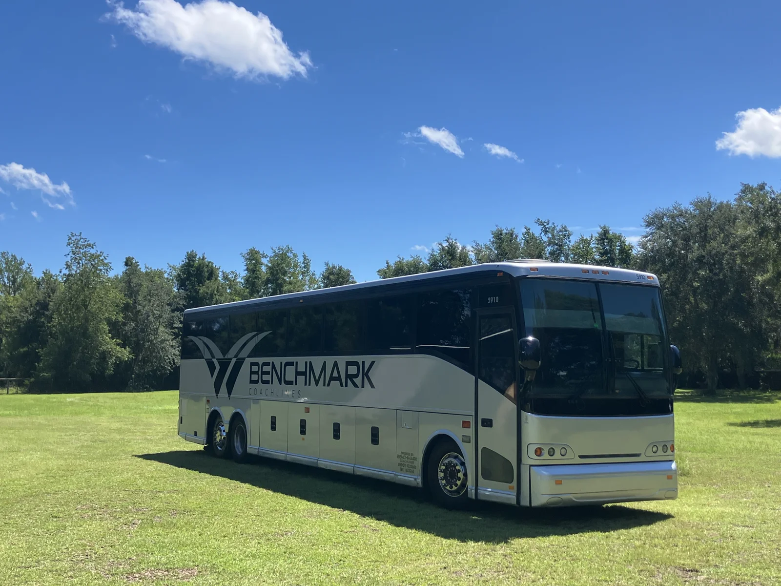 Students boarding a charter motorcoach for a Gainesville school field trip with a chaperone doing a headcount - Benchmark Coachlines